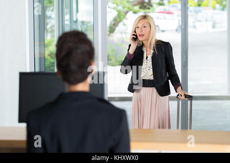 Businesswoman arrivent pour arrivée à parler au téléphone Banque D'Images