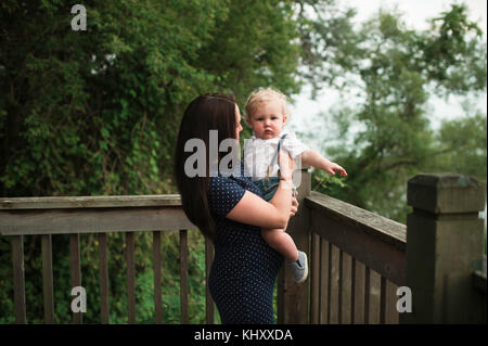 Femme enceinte exerçant son petit garçon sur balcon Banque D'Images
