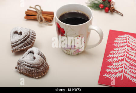 High angle view of cookies en forme de coeur avec une tasse de café chaud, bande de cannelle et de brindilles de sapin Banque D'Images