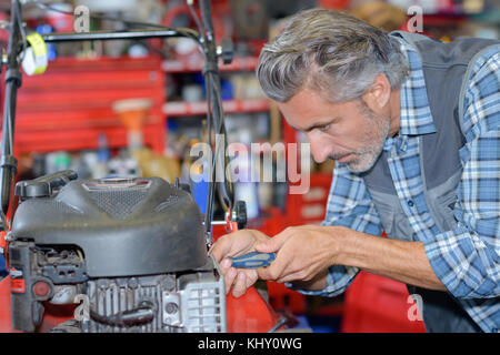 La réparation de moteur de tondeuse à gazon Banque D'Images