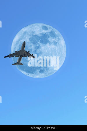 Jumbo jet airplane crossing lune de jour Banque D'Images