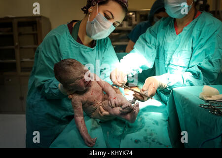 Médecin de salle d'opération de lale kilich montrant au nouveau-né à l'appareil photo Banque D'Images
