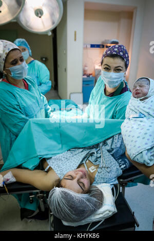 L'infirmière de salle d'opération montrant nouveau-né à mère Banque D'Images