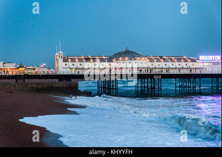 Brighton, East Sussex. 22 novembre 2017. Météo britannique. Un couple de fêtards profitez d'un plongeon dans les vagues en dessous de la jetée de Brighton au coucher du soleil après une journée ensoleillée et doux avec de forts vents côtiers. Credit : Francesca Moore/Alamy Live News Banque D'Images