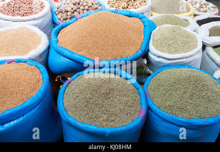 Sacs remplis d'herbes séchées, couscous, de sésame, d'arachide, arachides, noix, ail et affichée à un marché au Maroc. Banque D'Images