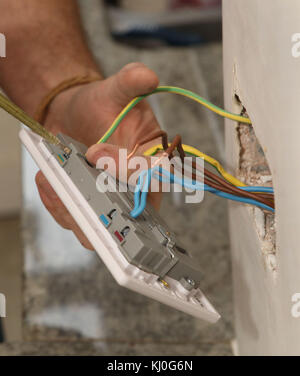 Richard Burr en installant une fiche USB dans un mur pour sa colonne de bricolage. Banque D'Images