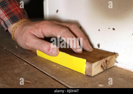 Richard Burr sablant un plancher en bois pour sa colonne de bricolage. Banque D'Images