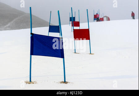 Ski enfants piste de course de slalom avec portes bleu et rouge. petite course de ski portes sur un poteau avec des enfants le ski dans l'arrière-plan. Banque D'Images