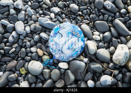 30ème anniversaire,ballon dégonflé,,,polluer, de la plage,sur,trouvé Ynyslas cailloux,plage, près de Borth,nord,de,Aberystwyth, Ceredigion,mi,Ouest,au Pays de Galles, Royaume-Uni, Royaume-Uni, Europe, Banque D'Images