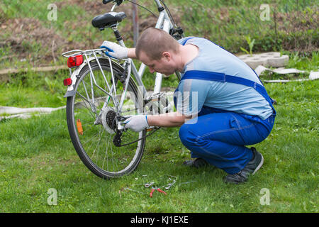 L'homme est la fixation du vélo. Régler les engrenages Banque D'Images