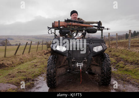 Un homme assis sur un quad (ATV) en train de tirer en faisant le contrôle vermin à Weardale dans le comté de Durham, dans le nord-est de l'Angleterre. Banque D'Images