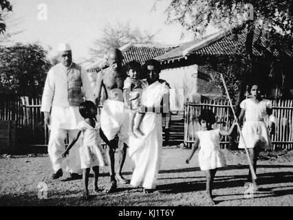 Mahatma Gandhi marcher avec sa grand-fille Saraswati ; son fils Shanti et les autres à l'Ashram Sevagram ; 1940 Banque D'Images