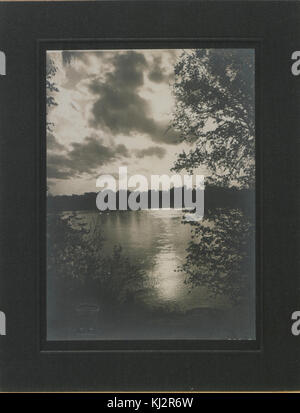 Une photographie atmosphérique de Saskatoon prise la nuit, illuminée par le clair de lune. L'image capture la beauté sereine et tranquille de la ville sous un ciel nocturne. Banque D'Images