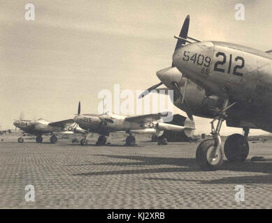 Plusieurs Lockheed P-38 Lightning sont alignés sur une piste de la seconde Guerre mondiale. Cet avion de chasse bimoteur a été utilisé par les Alliés pendant le conflit, remarquable pour sa conception distinctive et son rôle dans le combat aérien. Banque D'Images