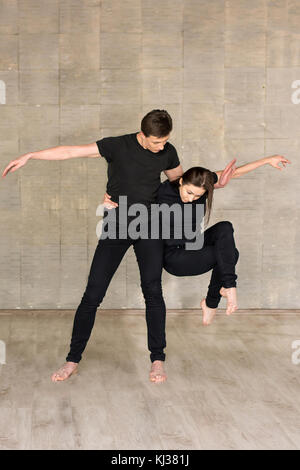 Le partenariat de la danse sur fond gris. Banque D'Images