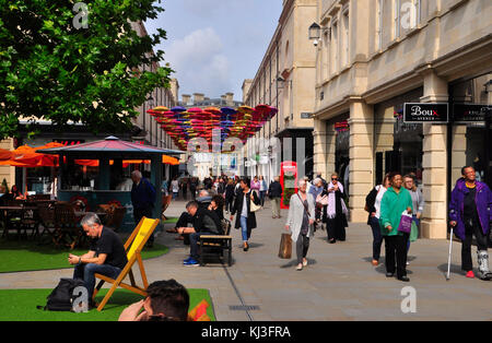 Clients mystères de profiter de la baignoire était enjoué lumineux décorations de la rue et vous détendre au soleil. Baignoire, Somerset, Angleterre.uk. Banque D'Images