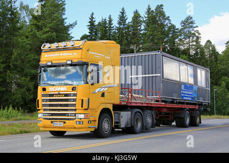 Forssa, Finlande - le 25 juillet 2015 : Scania 164g camion transporte une cabine portable portable. Les chalets sont souvent utilisés comme bureaux temporaires sur les chantiers. Banque D'Images