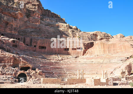 Amphithéâtre de l'époque romaine sculptée dans le grès rose à Pétra, en Jordanie. les façades de bâtiments creusés dans la roche derrière sont anciennes tombes. Banque D'Images