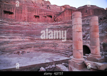 Amphithéâtre de l'époque romaine sculptée dans le grès rose à Pétra, en Jordanie. les façades de bâtiments creusés dans la roche derrière sont anciennes tombes. Banque D'Images