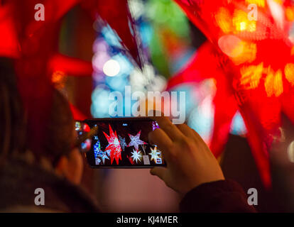 Un touriste prend une photo de lanternes de Noël à un décrochage dans le marché de Noël d'Édimbourg. Banque D'Images