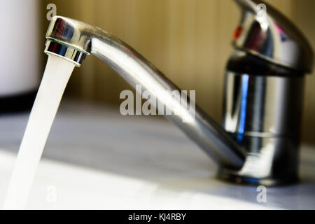 L'eau étant poored du robinet. Verser de l'eau du robinet Banque D'Images