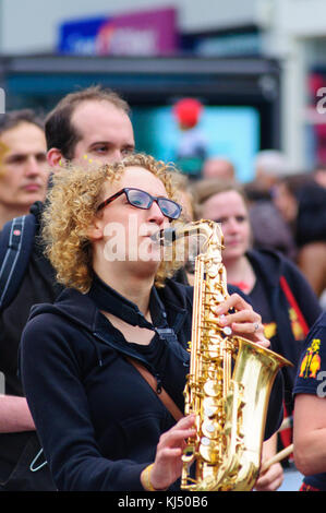 Femme jouant du saxophone musicien dans le carnaval de l'Edinburgh Jazz and Blues Festival sur le monticule à Princes Street Banque D'Images