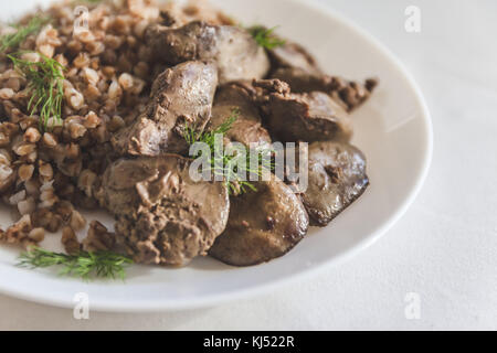 Foie de poulet compote et gruau de sarrasin sur une nappe blanche, en rétro tonifiant. Banque D'Images