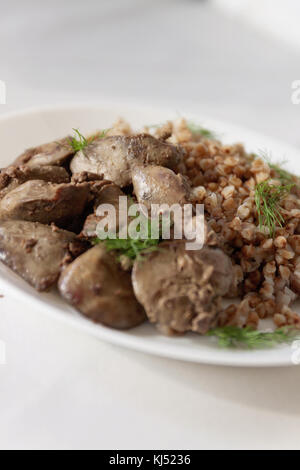 Foie de poulet compote et gruau de sarrasin sur une nappe blanche, en rétro tonifiant. Banque D'Images