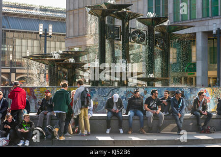 Berlin Alexanderplatz, les gens s'assoient autour de la base de la fontaine de l'Amitié Internationale sur la place principale à Alexanderplatz, Berlin, Allemagne. Banque D'Images