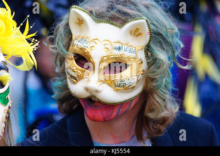 Interprète masculin portant un masque de chat en porcelaine dans le carnaval de l'Edinburgh Jazz and Blues Festival sur le monticule à Princes Street Banque D'Images