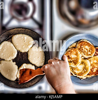 Femme fry crêpes dans une poêle sur une vieille cuisinière à gaz. concept : la cuisson. Vue de dessus. haut veiw Banque D'Images