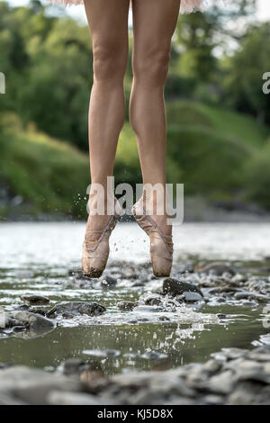 Ballerine sautant dans river Banque D'Images