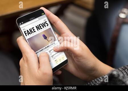 Concept : l'information à l'aide d'un téléphone numérique généré avec de fausses nouvelles sur l'écran. tous les écrans graphiques sont constitués. Banque D'Images