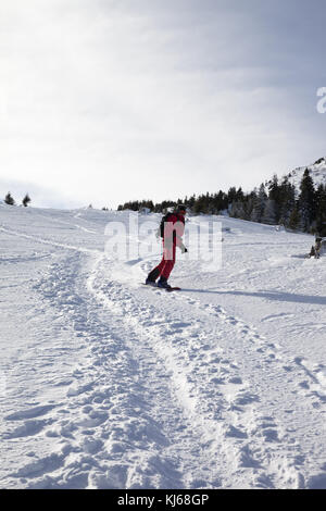 Snowboarder en descente sur pente de neige en hors-piste, en hiver matin. Carpates, l'Ukraine. Banque D'Images