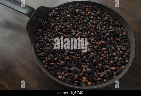 Un poêle avec du café fraîchement moulu de haricots. Banque D'Images