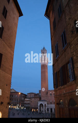 La Piazza del Campo et Palazzo Pubblico de Sienne au cours de la soirée, encadré par deux bâtiments. Banque D'Images