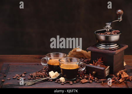 Les grains de café et d'une meuleuse sur table en bois avec cannelle et anis étoile. Banque D'Images