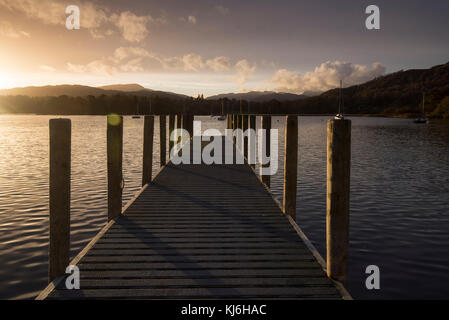 Coucher de soleil sur une jetée en bois à Waterhead Pier sur le lac Windermere près d'Ambleside, Cumbria Lake District Angleterre Banque D'Images