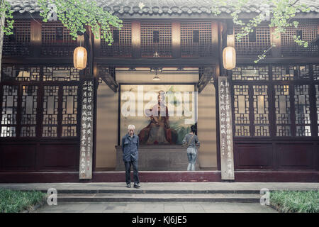 Homme âgé et jeune femme marchant paontement dans le parc commémoratif du Fu, regardant l'art et l'architecture du parc à Chengdu, Sichuan, Chine Banque D'Images