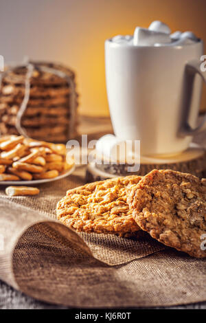 Automne hiver de la vie toujours recette maison gingembre biscuits au miel et de bagel, le cacao café tasse avec de la guimauve sur cuisine table en bois Banque D'Images