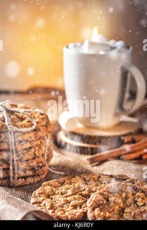 Automne hiver de la vie toujours recette maison gingembre biscuits au miel et de bagel, le cacao café tasse avec de la guimauve sur cuisine table en bois Banque D'Images