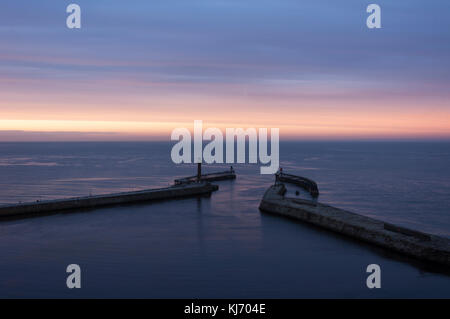 À la recherche vers le bas pour les quais de Whitby, dans le Yorkshire du nord sur une soirée comme le ciel l'automne éclaire de couleur que les couchers de soleil. Banque D'Images