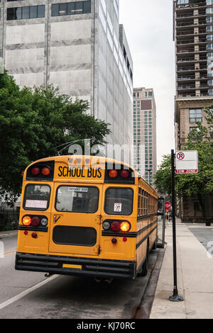 Un autobus scolaire stationné dans une rue, attendant la fin de la classe avec la porte avant ouverte, dans un temps gris. Vue de dos, Chicago, USA. Banque D'Images