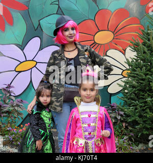 Portrait d'une mère et ses deux filles en costumes de Halloween aller trick ou traiter. Filles portant un costume de fée et sorcière costume. Banque D'Images