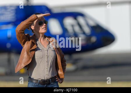 Jeune femme commander billet de visite par hélicoptère de l'aéroport sur tablette Banque D'Images