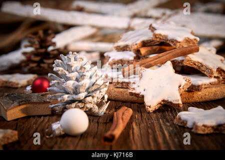 Étoiles à la cannelle biscuits pour Noël avec des pièces de pin et des boules de Noël rouge Banque D'Images