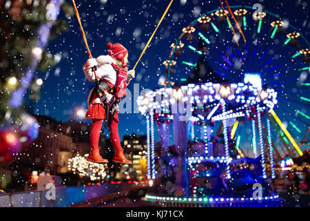 Enfant à Noël juste amusement. petite fille à saut park. kids aller au marché de Noël au centre-ville sur soirée froide. les enfants outd Banque D'Images