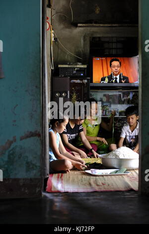 Famille vietnamienne préparant des crêpes de riz pour le marché à la maison dans un village local Banque D'Images