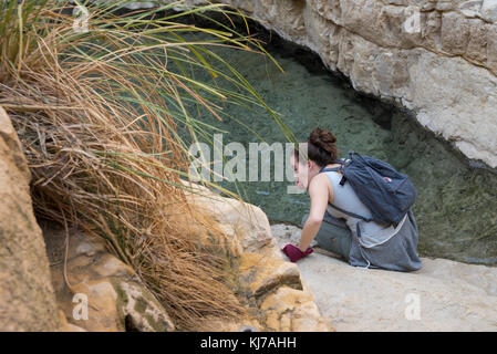 Teenage girl sitting on rock, Région de la Mer Morte, Israël Banque D'Images