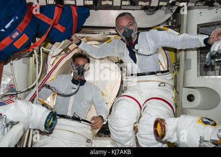 Expédition 53 L'astronaute américain Randy Bresnik, à droite, et Joe Acaba s'entraînant à enfiler leurs combinaisons spatiales à bord de la Station spatiale internationale pour les stocker le 19 novembre 2017 en orbite terrestre. Banque D'Images